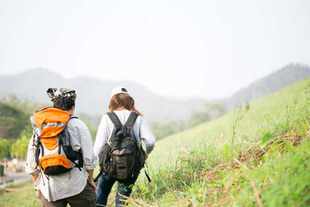 Couple of backpacking hikers going to mountain top and navigating by map paper. Backpackers or Hikers travel concept. Selective focus and vintage tone.の写真素材