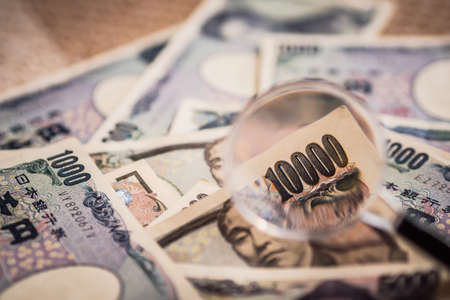Japanese Yen Banknotes shot stack layers on floor with magnifying glass for selective focus.. japanese currency. financial and economy money concept.の写真素材