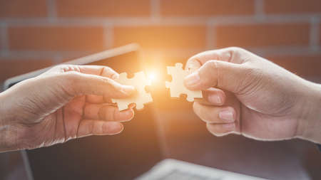 Business solutions, Businesswoman hand connecting jigsaw with businessman hand. success and strategy...