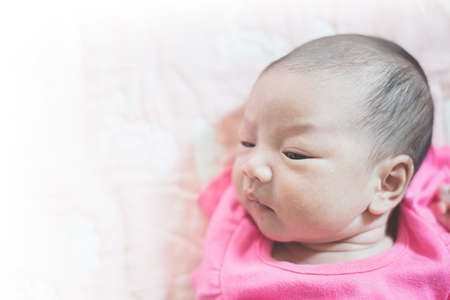 The infant is crying and lying on the bed.の写真素材