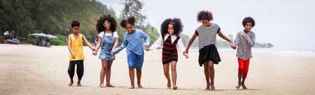 Funny vacation. Children or kids playing and romp together at the beach on holiday. Having fun after unlocking down the city from COVID19. Seven African American kids. Ethnically diverse conceptの写真素材