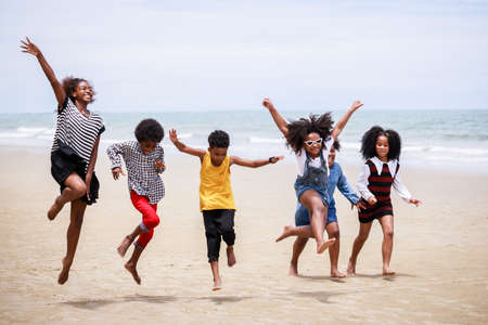 Funny vacation. Children or kids playing and romp together at the beach on holiday. Having fun after...