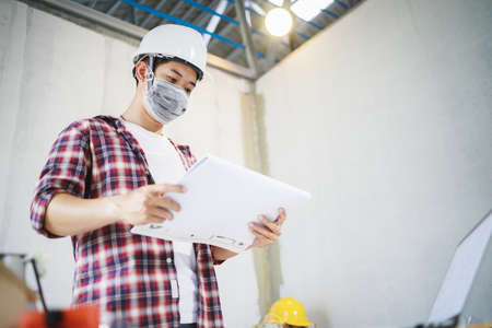 Engineer or Foreman wearing disposable face mask before working to protecting viruses (COVID-19) and...