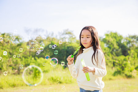 A little girl blowing soap bubbles with have fun and enjoyed on sunny days on weekend.