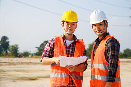 Portrait of Two Engineer, field engineer, foreman, owner standing in construction site project and...