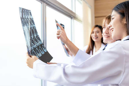 Senior doctor woman teaching doctor student woman. How to analyze the X-ray film. Radiology department.の写真素材
