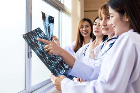 Senior doctor woman teaching doctor student woman. How to analyze the X-ray film. Radiology department.の写真素材