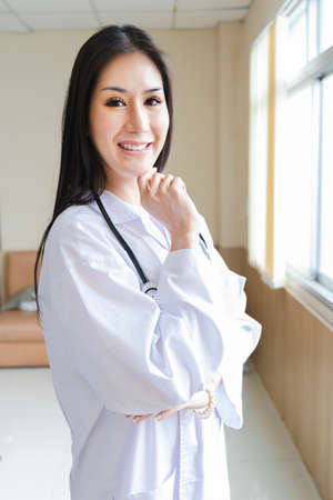 portrait of smart female doctor with a Stethoscope standing at reception of the hospital.の写真素材