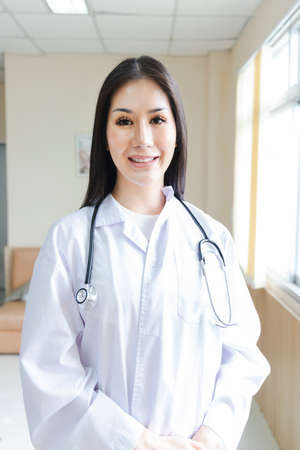 portrait of smart female doctor with a Stethoscope standing at reception of the hospital.の写真素材