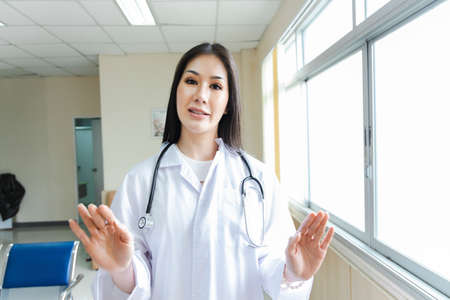 portrait of smart female doctor with a Stethoscope standing at reception of the hospital.の写真素材