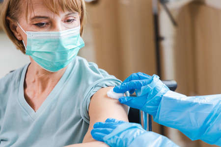 elderly woman patient getting covid-19 or coronavirus vaccine in a wheelchair âat the hospital.の写真素材