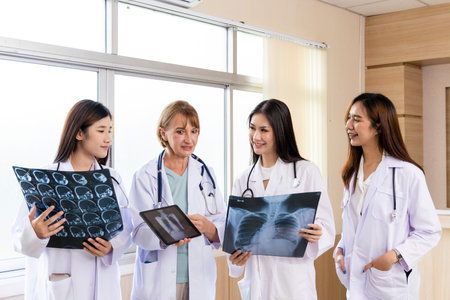 Senior doctor woman teaching doctor student woman. How to analyze the X-ray film. Radiology department.の写真素材