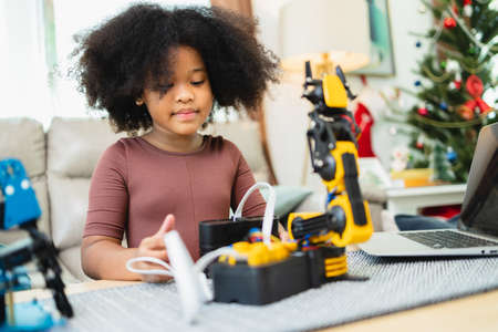 Two African American girls learned robot arms with a program computer. Innovative technology mechanical for Assistive Technologyの写真素材