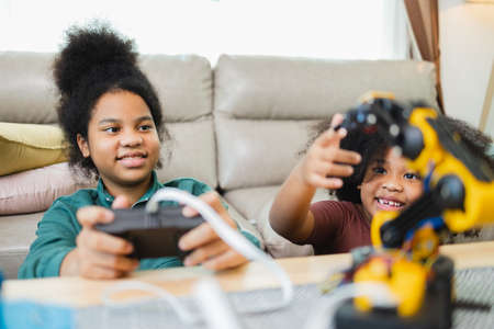 Two African American girls learned robot arms with a program computer. Innovative technology mechanical for Assistive Technologyの写真素材