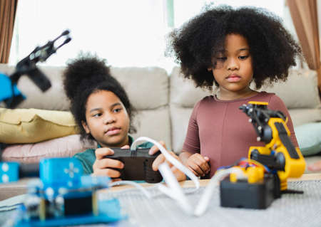 Two African American girls learned robot arms with a program computer. Innovative technology mechanical for Assistive Technologyの写真素材