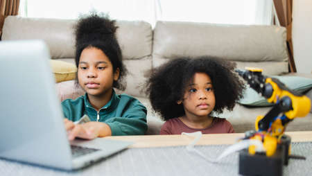 Two African American girls learned robot arms with a program computer. Innovative technology mechanical for Assistive Technologyの写真素材