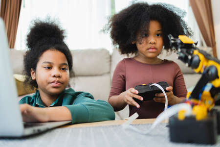 Two African American girls learned robot arms with a program computer. Innovative technology mechanical for Assistive Technologyの写真素材