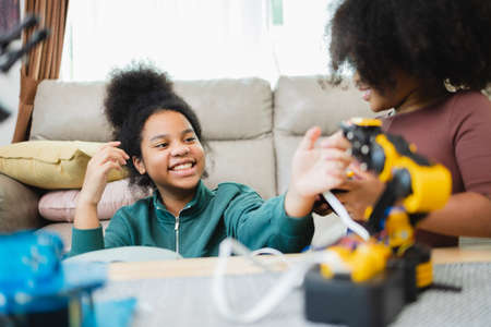 Two African American girls learned robot arms with a program computer. Innovative technology mechanical for Assistive Technologyの写真素材
