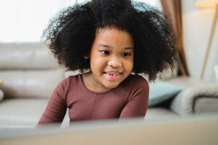 African American girl have fun working together while studying online using computers at home.の写真素材