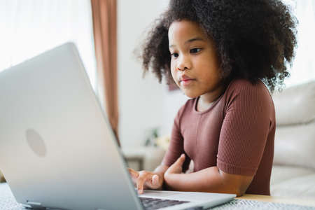 African American girl have fun working together while studying online using computers at home.の写真素材