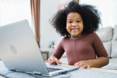 African American girl have fun working together while studying online using computers at home.の写真素材