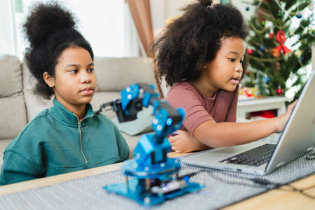 Two African American girls learned robot arms with a program computer. Innovative technology mechanical for Assistive Technologyの写真素材
