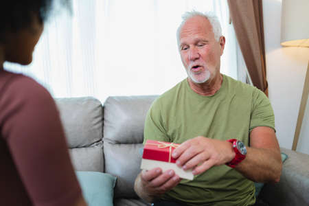 African American girl surprise her  senior grandfather for Christmas gift at home