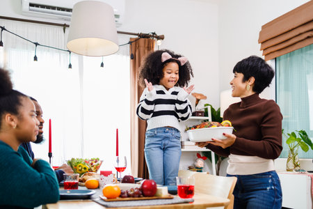 African American family. Merry Christmas. Happy family are having dinner at home. Celebration holiday and togetherness near Christmas tree.の写真素材
