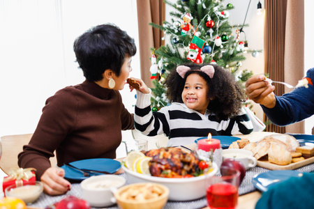 Happy family are having dinner at home. Celebration holiday and togetherness near Christmas tree. African American family. Merry Christmas.の写真素材