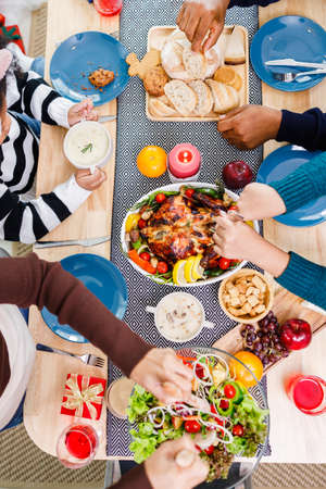 Top view of Happy family is having dinner at home. Celebration holiday togetherness near Christmas tree. African American family.の写真素材