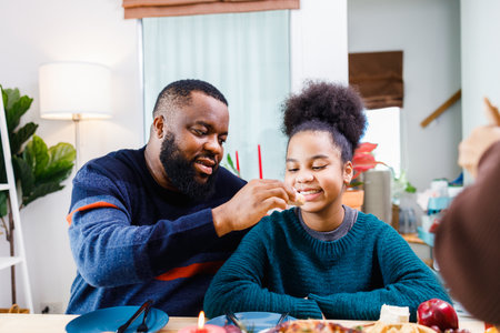 Happy family are having dinner at home. Celebration holiday and togetherness near Christmas tree. African American family. Merry Christmas.の写真素材