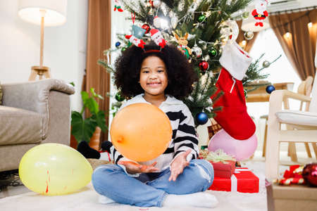 African American family help decorate the Christmas tree at home. Merry Christmas.の写真素材