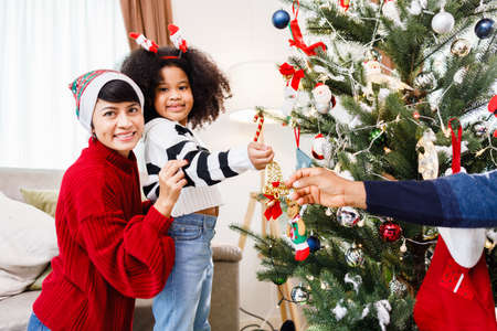 African American family help decorate the Christmas tree at home. Merry Christmas.の写真素材