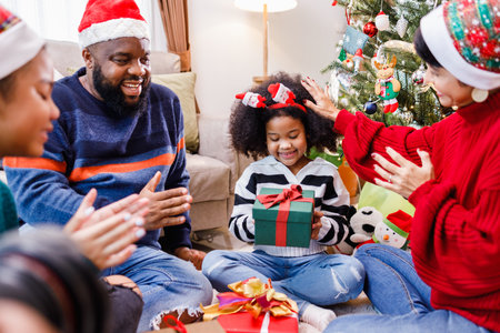 African American family surprising with a gift on Christmas day. Merry Christmas. Happy family.の写真素材