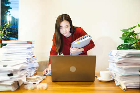 Businesswoman stand during working urgent job at desk at home at night. Workaholic people concept