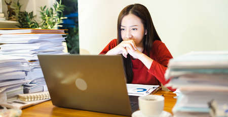 Overwork people. Asain woman doing overtime at home at night. Workaholic people conceptの写真素材