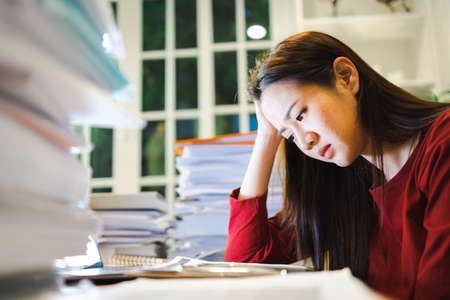 A Stress Woman has a headache during working by laptop computer in a night coworking spaceの写真素材