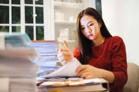 Asian Female Accountant keeps documents during overtime at night. Workaholic peopleの写真素材