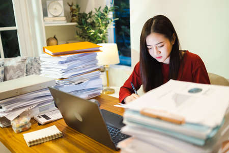 Young Asian female entrepreneur freelancer working by laptop computer in night coworking spaceの写真素材