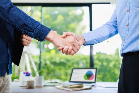 Business people shaking hands, finishing up meeting at home officeの写真素材