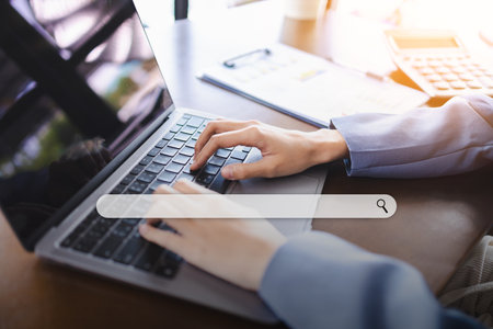 Data Search Technology Search Engine Optimization Concept. Hand of Businesswoman Searching Browsing Internet Data Information with blank search bar on laptop screenの写真素材