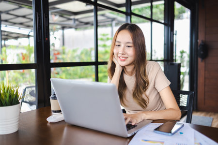 Female freelancer working using her laptop in cafe. Working online technology and modern devices conceptの写真素材