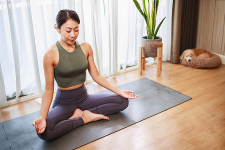 Find Peace and Relaxation with an Asian Woman's Yoga Practice in Sports Clothingの写真素材