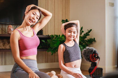 Experience the Joy of Family Yoga with an Asian Teacher and Girl's Virtual Classの写真素材