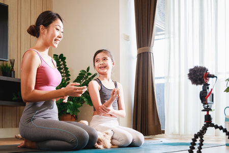 Asian woman yoga teacher and Girl filming yoga online class on video.の写真素材
