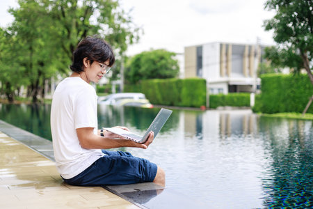 Laptop Work by the Poolside for Businessman on Vacation in Casual Wearの写真素材