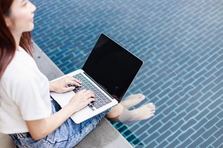 Investor Balances Business and Leisure by Trading Stocks Poolside in Rural Real Estate Hotelの写真素材