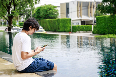 Entrepreneur Combines Work and Leisure on Holiday with Laptop by the Swimming Poolの写真素材