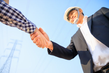 Asian engineers celebrate successful project with handshakeの写真素材
