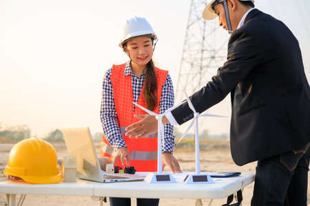 Construction engineers reviewing blueprints on siteの写真素材